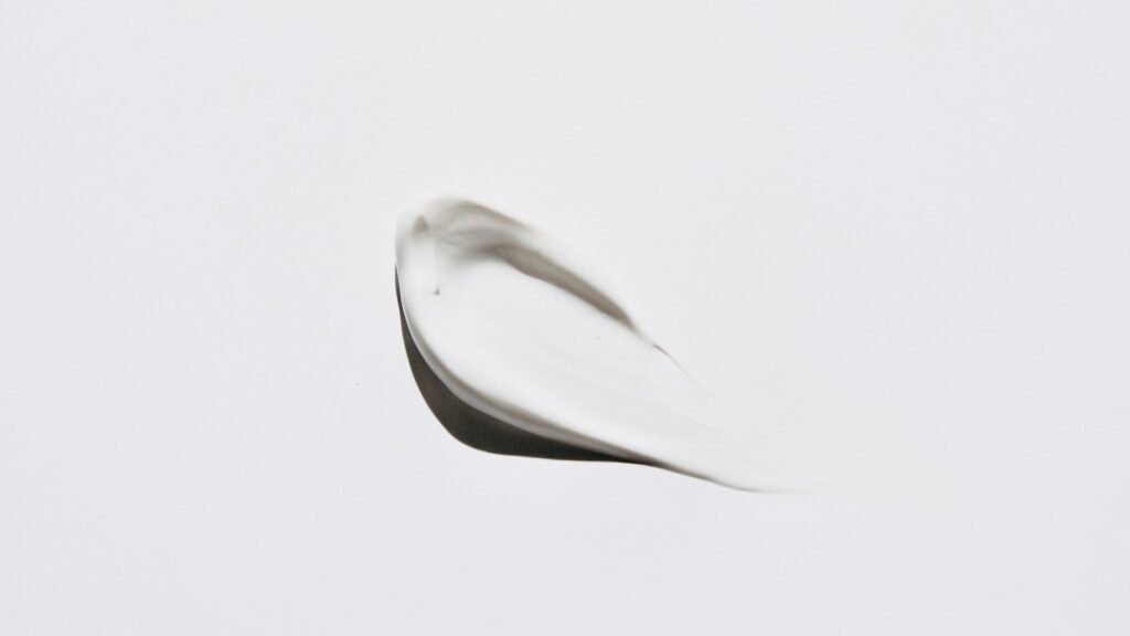 A smear of white cosmetic cream on a white background