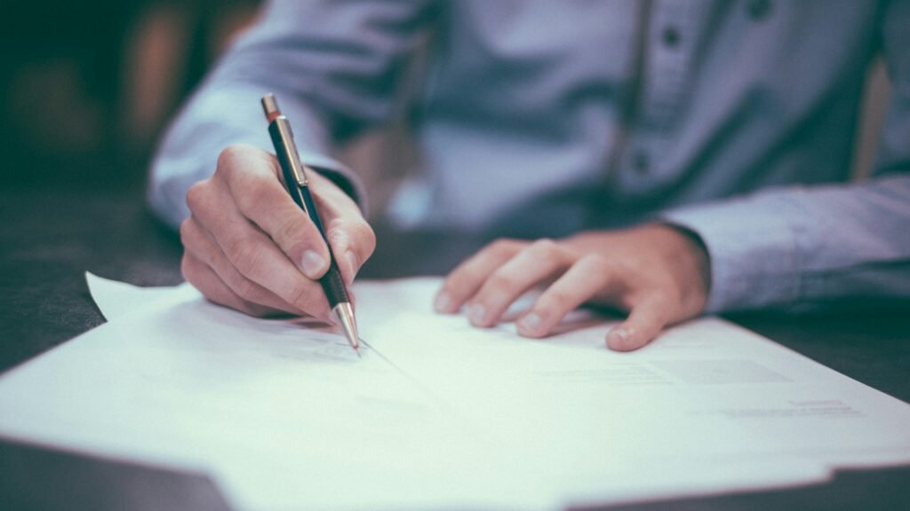 Person writing on paper at a desk